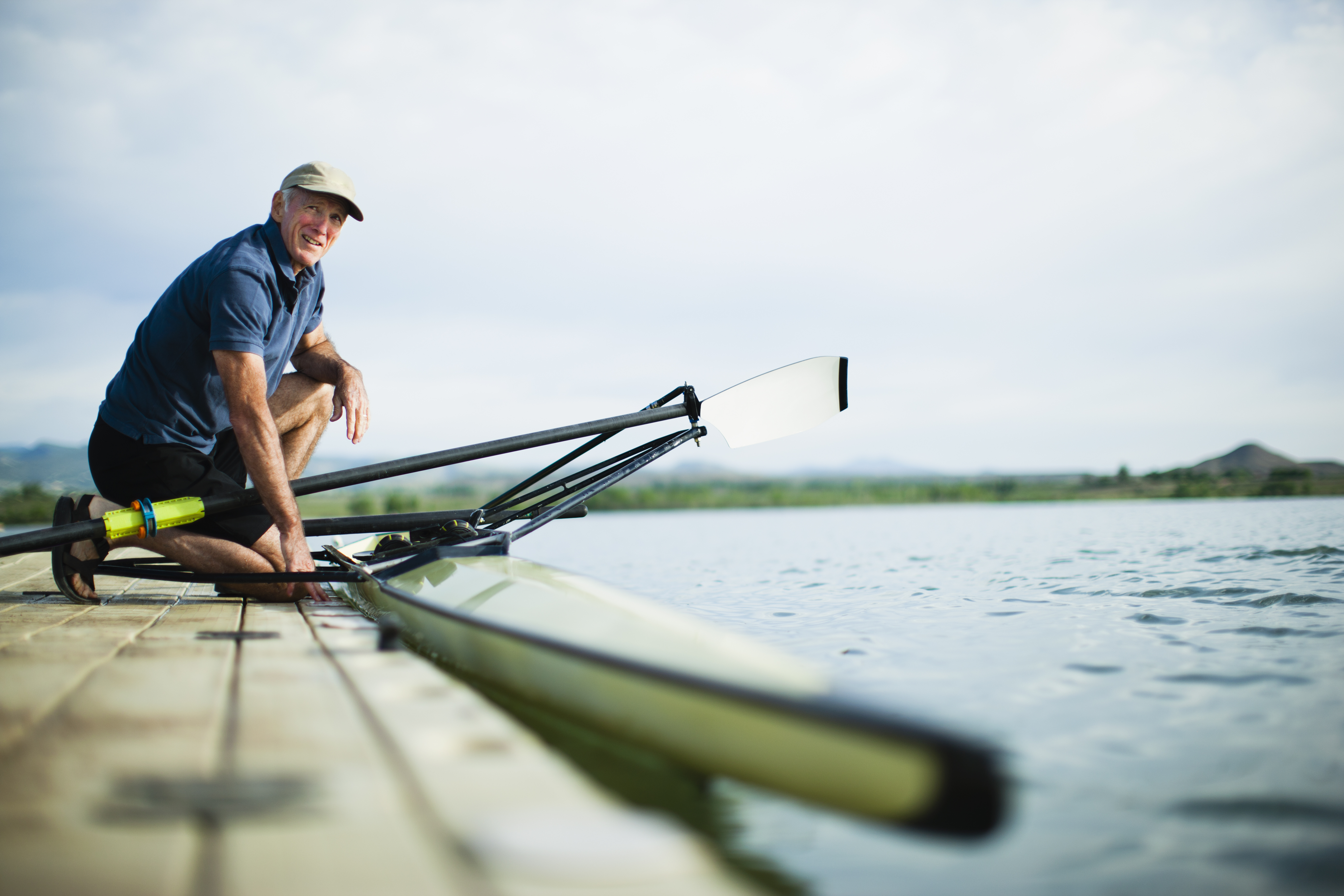 Man In Landscape,usa,a Middle Aged Man On A Jetty Preparing A Rowing Boat For An Outing.